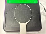 une raquette de tennis posée sur une table, à côté d'un ordinateur portable