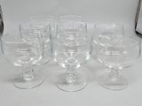 six wine glasses sitting on a white table