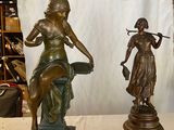deux statues représentant une femme et un homme assis sur un banc