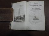 un livre ouvert sur une table, avec une image représentant une tour en arrière-plan