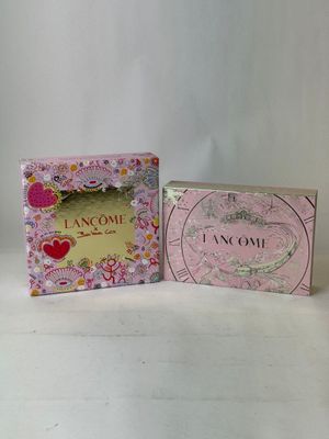 two small boxes of perfume sitting next to each other on a table