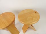 two small wooden stools sitting next to each other on a white surface