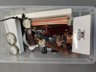 un bac en plastique rempli de montres diverses et d'autres objets
