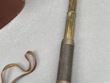 an old brass telescope with a leather case next to it and a pair of scissors