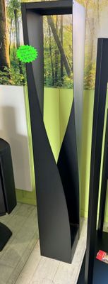 two tall black vases with green leaves on them