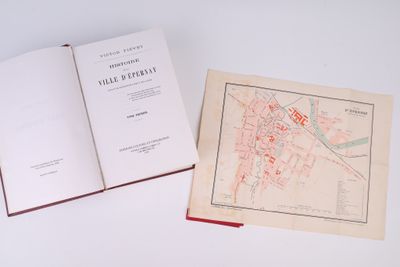 un livre ouvert posé sur une table, à côté d'une carte