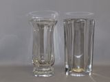 two tall glass vases sitting next to each other on a table