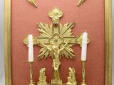 gold framed picture of a crucifix with candles and a cross