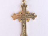 pendentif en forme de croix en plaqué or sur fond blanc, avec un fond blanc