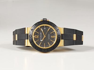 black and gold watch on a white surface with a white background