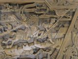 a wooden carving of a man riding on a horse