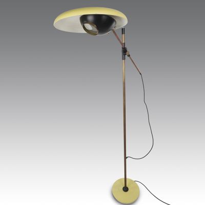 a yellow floor lamp with a black shade on top of it