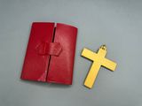 a red wallet with a cross on it next to a red wallet