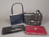 three purses and a wallet sitting on a table