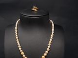 a pearl necklace with a gold clasp on a mannequin