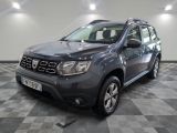 une photo d'une dacia grise garée sur un sol en damier