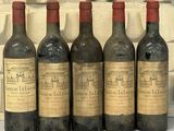six bouteilles de vin sont alignées sur une table