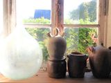 many vases sitting on a window sill in front of a window