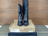 les bottes noires sont posées sur une boîte, elle-même posée sur une table