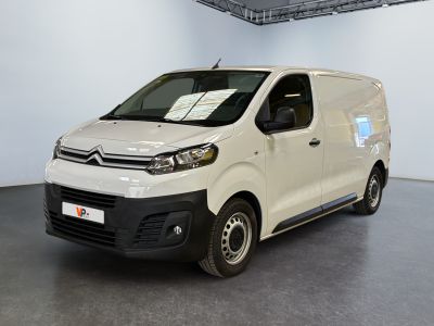 La camionnette blanche est garée dans la grande salle du bâtiment.