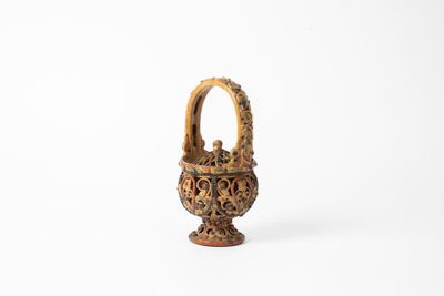 an image of a small vase with a handle on a white surface