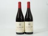 deux bouteilles de vin rouge posées l'une à côté de l'autre sur une surface blanche