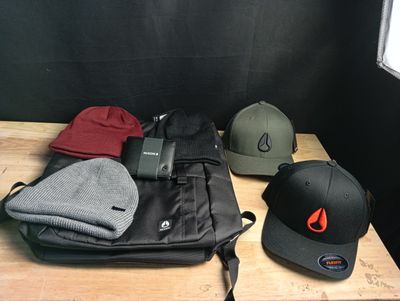 several hats and a backpack are sitting on a table in a room