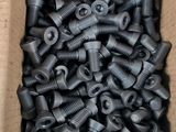 a cardboard box filled with black screws and nuts