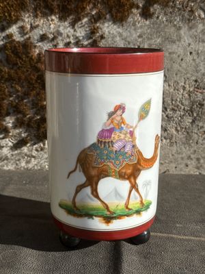 a vase with a picture of a woman riding a camel