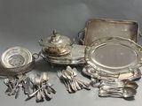 un plateau en argent sur lequel sont disposés des couverts et des cuillères en argent