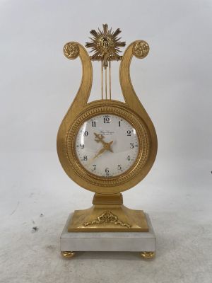 a gold clock sitting on top of a white table