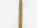 a metal pan with a wooden handle on a white surface