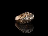 une image d'une bague en or et en diamant sur une surface noire