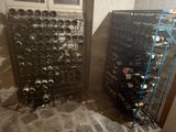 two racks with wine bottles on them in a room