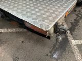 a flat bed on the back of a truck in a parking lot