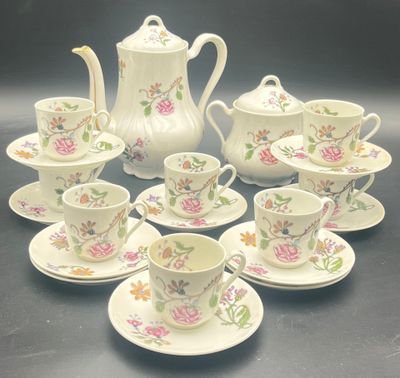 nine cups and saucers and a teapot on the table