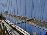 un long rail métallique appuyé contre un mur bleu
