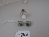 Deux bagues et une paire de boucles d'oreilles sont posées sur une table blanche.