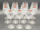 six clear wine glasses are lined up in a row on a table