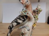 a figurine of a bird sitting on a tree branch