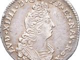 une vieille pièce d'argent surmontée d'une couronne