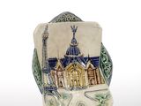 a small vase with a picture of a building on it