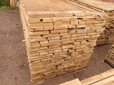 several stacks of wooden planks stacked on top of each other in a yard