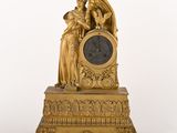 une horloge en or surmontée d'une statue