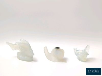 trois morceaux de verre posés les uns à côté des autres sur une surface blanche