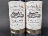 two bottles of wine sitting next to each other on a table