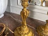two gold candlesticks sitting on a marble table