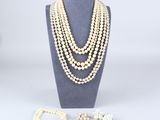 un ensemble composé d'un collier et d'un bracelet en perles blanches, présenté sur un mannequin