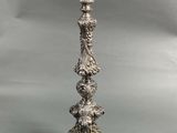 a silver plated candle holder on a grey background