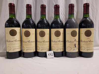 six bottles of red wine are lined up on a table